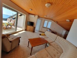 a living room with a couch and a large window at Apartmani Miljak Omiš in Omiš