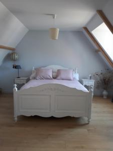 a bedroom with a white bed with pink pillows at Thérouanne en Berry in Plaimpied-Givaudins +26 photos