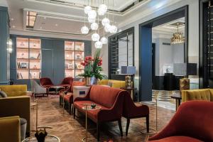 a lobby with chairs and tables and a chandelier at LUME Boutique Hotel, Autograph Collection in Frankfurt/Main