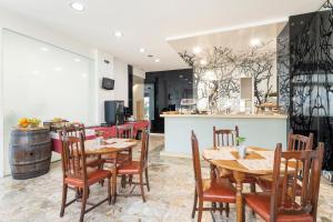 restauracja z drewnianymi stołami i krzesłami oraz bar w obiekcie Hotel Alda Camiño Inglés w mieście Ordes