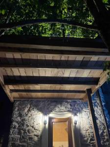 ein Haus mit einem Holzdach und einer Tür in der Unterkunft Paradis pour deux, pierres, piscine, Cinque Terre in Riccò del Golfo di Spezia