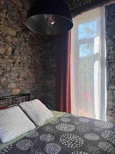 Schlafzimmer mit einem Bett und einem Fenster in der Unterkunft Paradis pour deux, pierres, piscine, Cinque Terre in Riccò del Golfo di Spezia