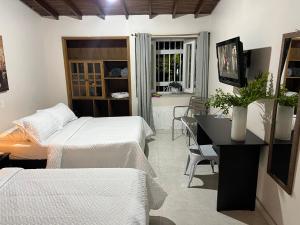1 dormitorio con 2 camas, escritorio y ventana en New Memphis Hostal, en Medellín