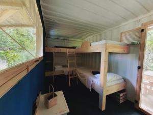 sypialnia z 2 łóżkami piętrowymi i oknem w obiekcie Le Camptainer, Glamping Eco Farm Stay w mieście Grand Sable