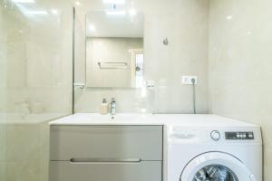 a white bathroom with a washing machine and a sink at Elegant Suite 4 Near the Beach in Ayía Marína