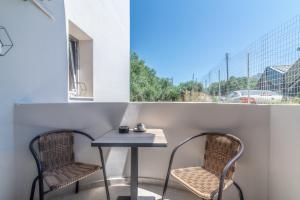 a table and two chairs on a balcony with a window at Elegant Suite 4 Near the Beach in Ayía Marína
