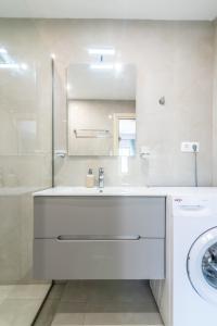 a white bathroom with a sink and a washing machine at Elegant Suite 4 Near the Beach in Ayía Marína