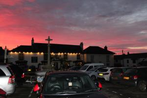 um parque de estacionamento com carros estacionados em frente a uma igreja em Old Temperance House B&B St Keverne em Saint Keverne