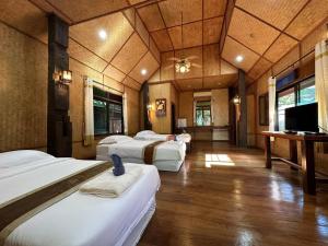 a room with four beds and a flat screen tv at Dreamer Club Resort Treehouse Suspension Bridge Pool in Chiang Mai