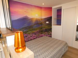 - une chambre ornée d'une peinture de montagne dans l'établissement Charmant studio lumineux avec Wifi, à La Bourboule