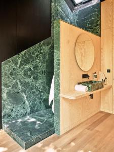 a bathroom with a green marble wall with a mirror at Hutstuf The Eagle & Private Outdoor Spa in La-Roche-en-Ardenne