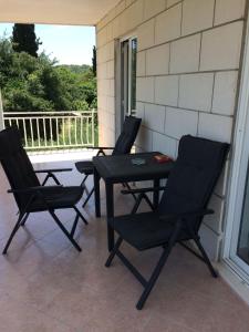 three black chairs and a table on a porch at Apartments Biočić in Korčula