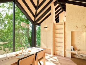 a small house with a large window and a table at Hutstuf The Eagle & Private Outdoor Spa in La Roche-en-Ardenne