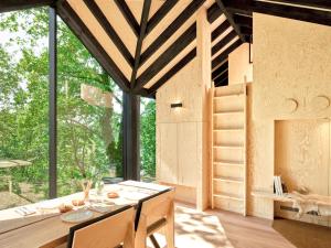 a small house with a large window and a table at Hutstuf The Eagle & Private Outdoor Spa in La-Roche-en-Ardenne