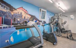 einen Fitnessraum mit Cardio-Geräten und einem Wandbild in der Unterkunft 2 Bedroom Awesome Home In Magliolo in Magliolo