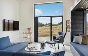 ein Wohnzimmer mit blauen Möbeln und einem großen Fenster in der Unterkunft Lovely Home In lbk With House A Panoramic View in Ålbæk