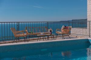 a patio with three chairs and a table next to a pool at Villa Krstac in Budva