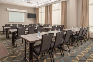 a conference room with tables and chairs and a screen at Residence Inn Seattle East/Redmond in Redmond