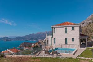 a house with a swimming pool next to the water at Villa Krstac in Budva