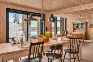 cocina y comedor con mesa de madera grande y sillas en Private Room in Beautiful Mountain Home w/ Sauna en Beitostøl