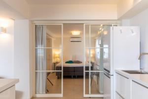 una cocina con una puerta de cristal que conduce a un dormitorio en One Ocean Boutique Apartments & Suites Bonaire, en Kralendijk