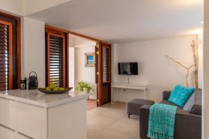 a kitchen and a living room with a couch at One Ocean Boutique Apartments & Suites Bonaire in Kralendijk