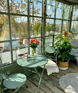 une table et des chaises en verre dans une pièce avec fenêtres dans l'établissement Attico&Nuvole, à Turin