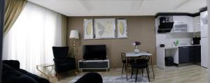 een woonkamer met een bank en een tafel met stoelen bij Fully Equipped Apartment Istanbul (Zarif26) in Avcılar