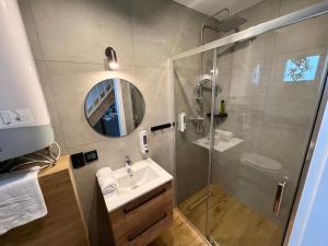 a bathroom with a shower and a sink and a mirror at Jaśminowa Park in Zator