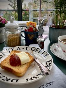 a plate with a piece of bread with jam and butter at Attico&Nuvole in Turin