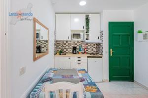 a kitchen with a green door and a table at Lima Vivienda Vacacional in Puerto del Carmen
