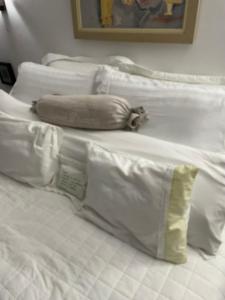 Chalé romântico , rústico e vista de tirar o fôlego في غواراميرانغا: مجموعة من الوسائد البيضاء على سرير