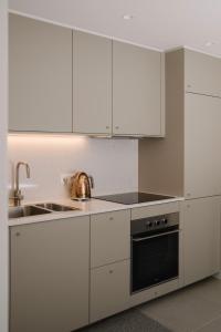 a kitchen with white cabinets and a sink and a stove at Aldoar House in Porto