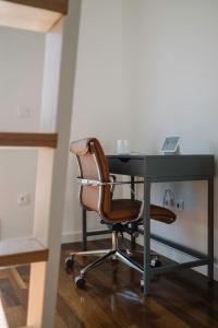 an office chair sitting at a desk with a laptop at Aldoar House in Porto
