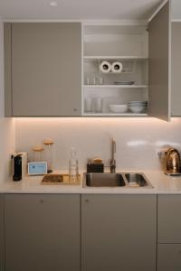 a kitchen with white cabinets and a sink at Aldoar House in Porto