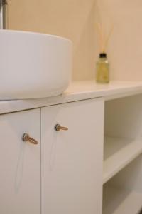 a white cabinet with a bowl on top of it at Aldoar House in Porto