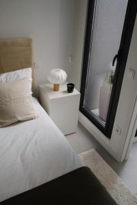 a bedroom with a bed and a lamp on a night stand at Aldoar House in Porto