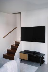 een woonkamer met een flatscreen-tv aan de muur bij Aldoar House in Porto