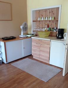 una cocina con electrodomésticos blancos y armarios de madera en Großer Schlafraum in ehemaliger Schule, en Raiding