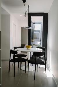 a dining room with a white table and black chairs at Aldoar House in Porto