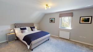1 dormitorio con cama y ventana. en Braeside - Family home in Nethy Bridge en Nethy Bridge