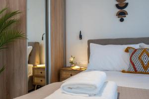 a bedroom with a bed and a mirror at Evora Suites in Chania Town