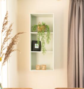ein Regal in einem Wohnzimmer mit einer Pflanze in der Unterkunft Appartement Zuiderstrand in Zoutelande