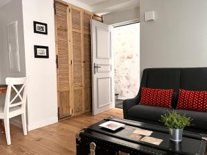 a living room with a black couch and a table at Les Petits Volets 3 appartements au choix in Antibes
