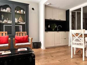 a kitchen with white cabinets and a table and chairs at Les Petits Volets 3 appartements au choix in Antibes