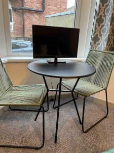 a table and two chairs with a computer monitor on it at 2 Bed ground floor apartment, sleeps 4 with free parking in Harrogate