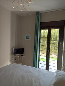 una camera con letto, televisore e finestra di Beach Apartment Puerto Banus Marbella a Estepona