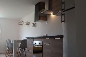 a kitchen with a counter and a table with chairs at Le petite maison du Crembreux in Marquise