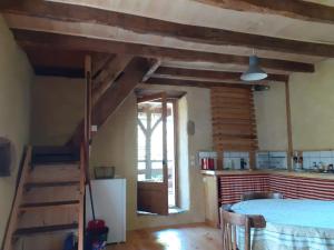 a room with wooden ceilings and a table and a staircase at La maison parfumée in La Valade +8 photos