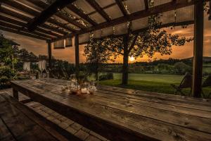 - une table en bois sur une terrasse avec vue sur le coucher du soleil en arrière-plan dans l'établissement Villa degli Amanti - Homelike Villas, à Terranuova Bracciolini